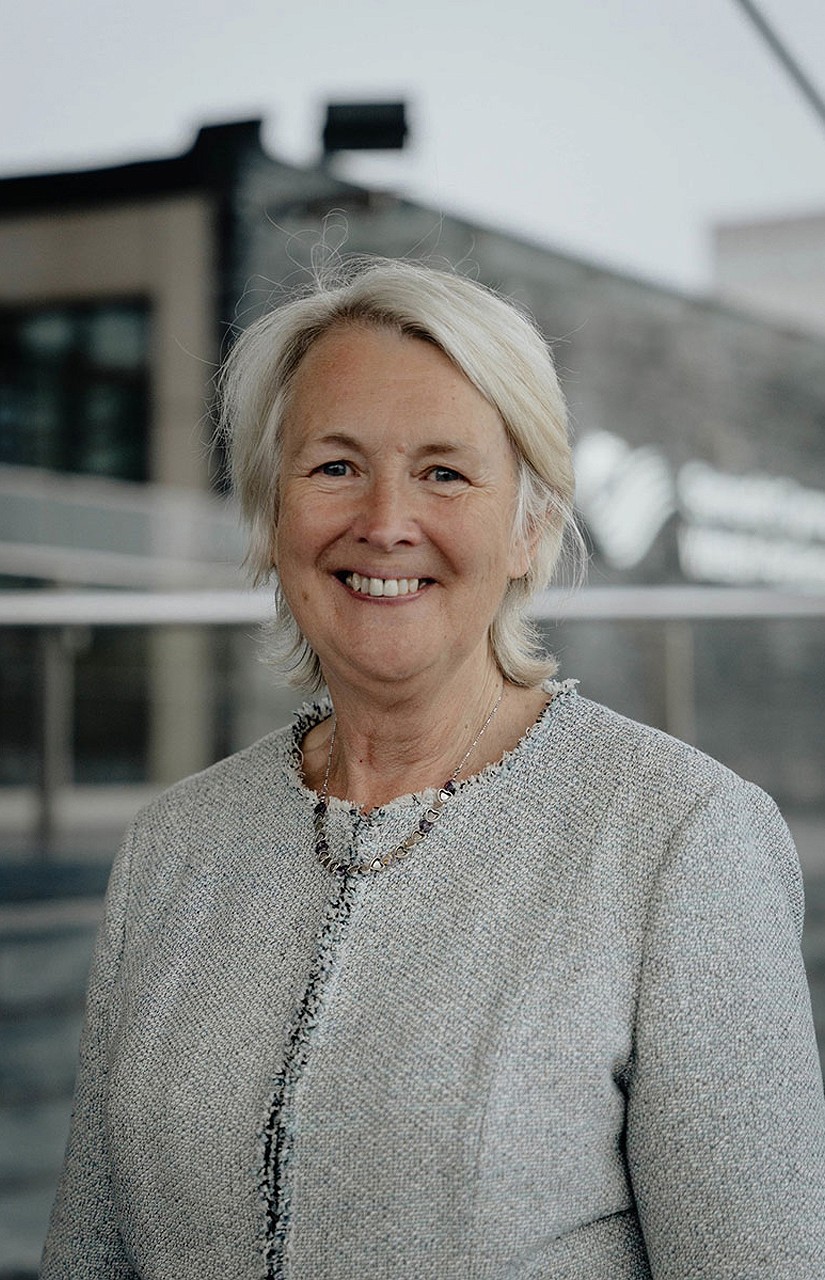 Sian Gwenllian yn sefyll tu allan yn gwenu - eng