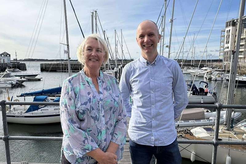 Sioned Williams with Aled Roberts with boats behind them